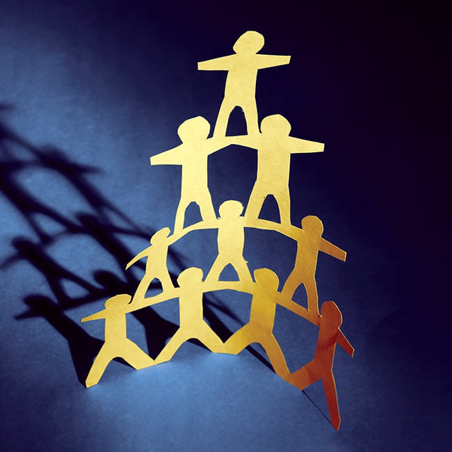A pyramid of cutout paper people all connected