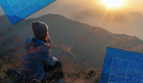 A woman sitting outside looking out at the sunrise/sunset, blueprints at corners of image