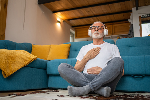 Man sitting on floor practicing guided meditation