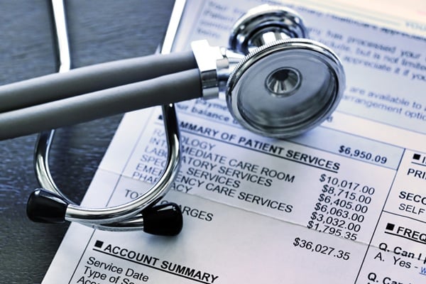 Stethoscope atop bill for medical treatment services.