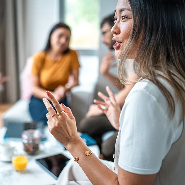 Woman speaking to someone in a group of people